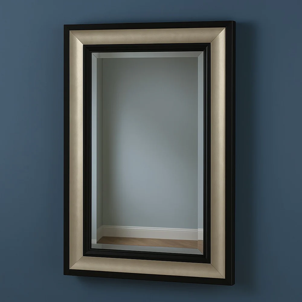 Rectangular wall mirror with a layered black and metallic frame, mounted on a dark blue wall, reflecting a modern interior with light gray walls and wooden flooring.