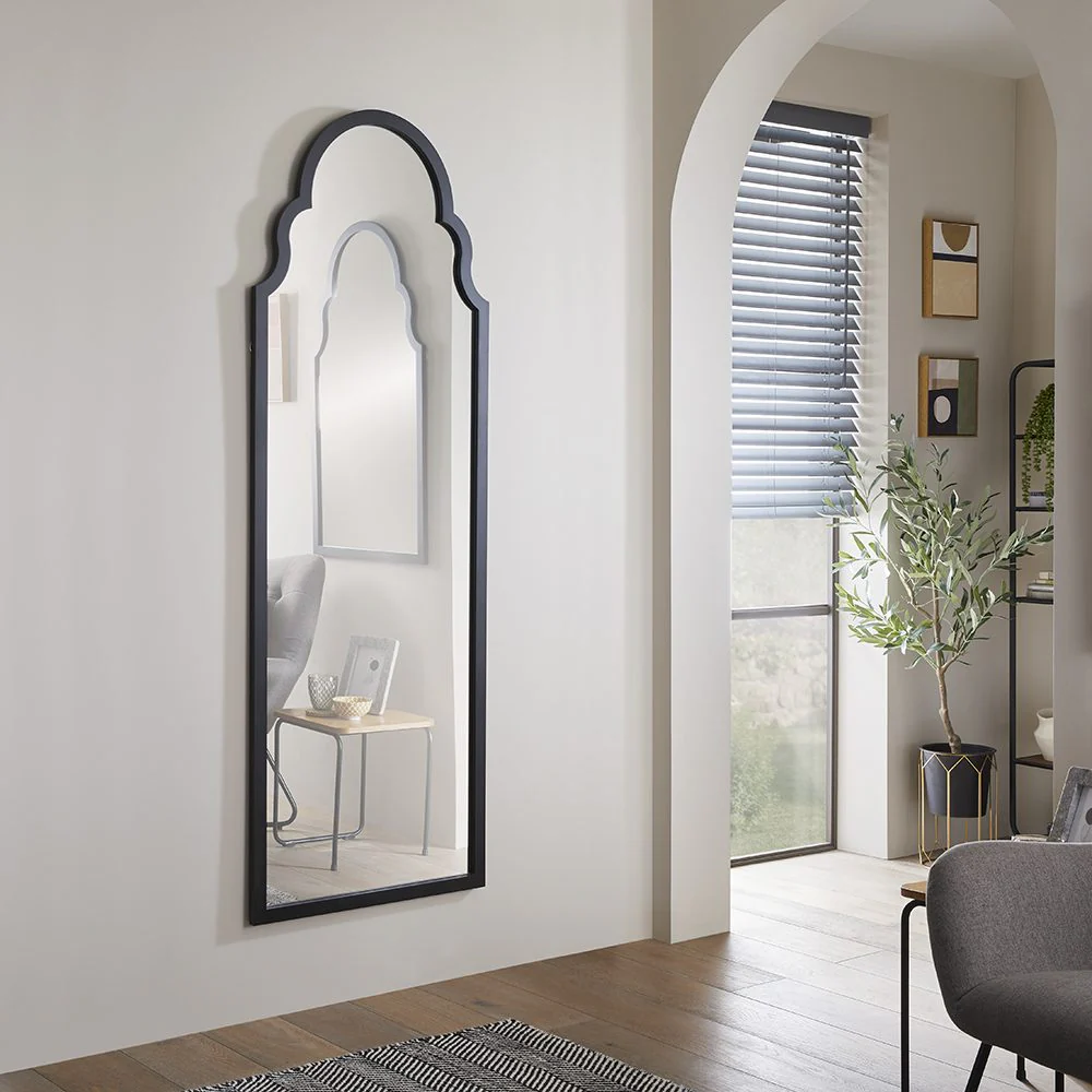 Moroccan-inspired silhouette mounted on a light wall, reflecting a cozy room with a gray chair, side table, and decorative accents