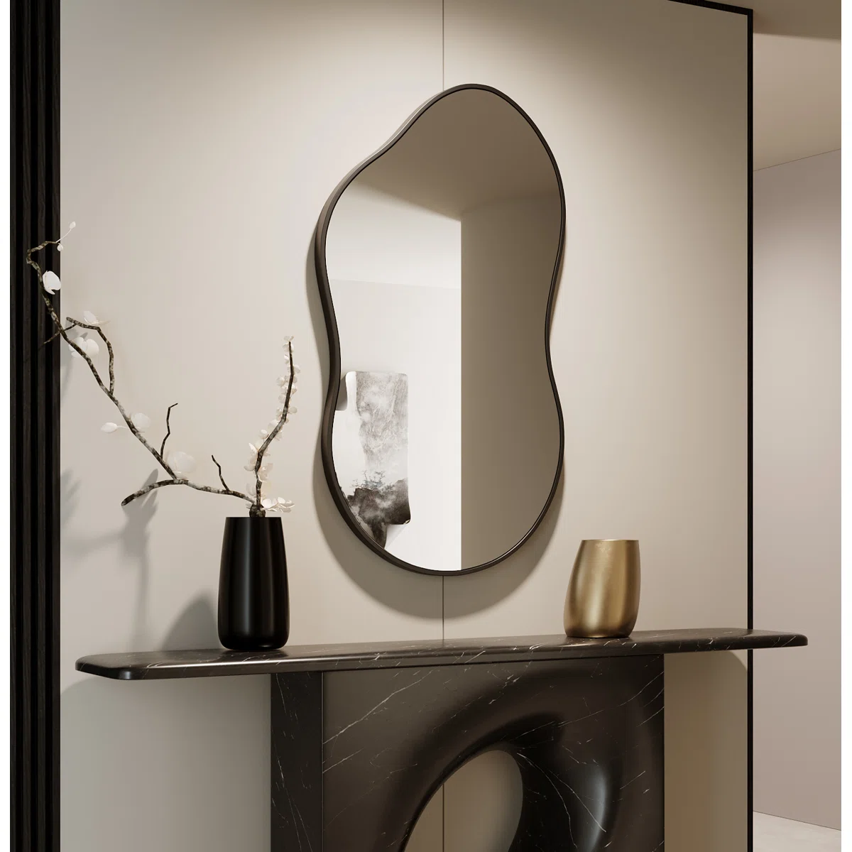 Irregularly shaped wall mirror with a matte black frame mounted on a light wall, reflecting abstract art and decor in a modern room setting.