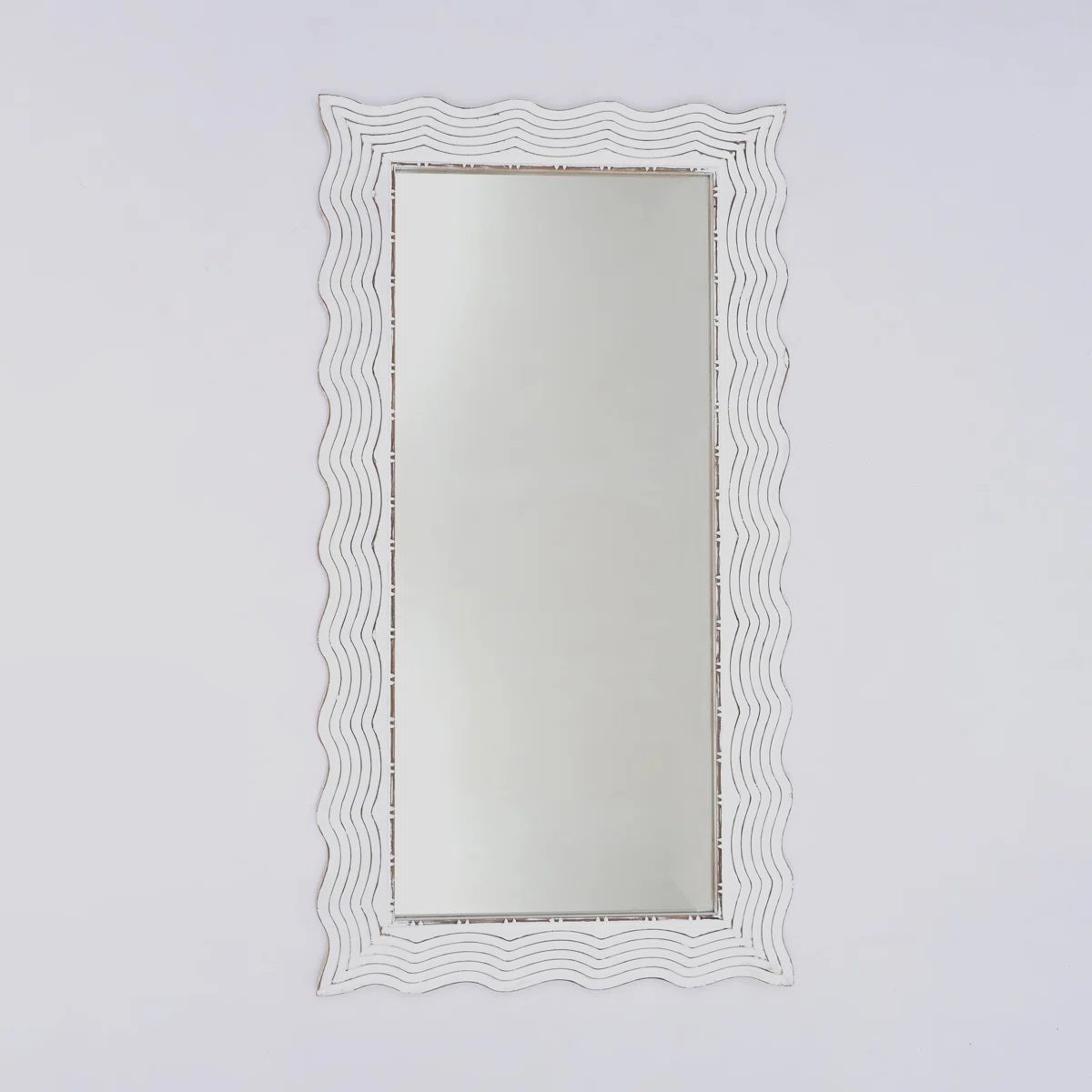 Elevate your interiors with this elegant rectangular wall mirror featuring a hand-finished antique white frame and gently scalloped wave edges.