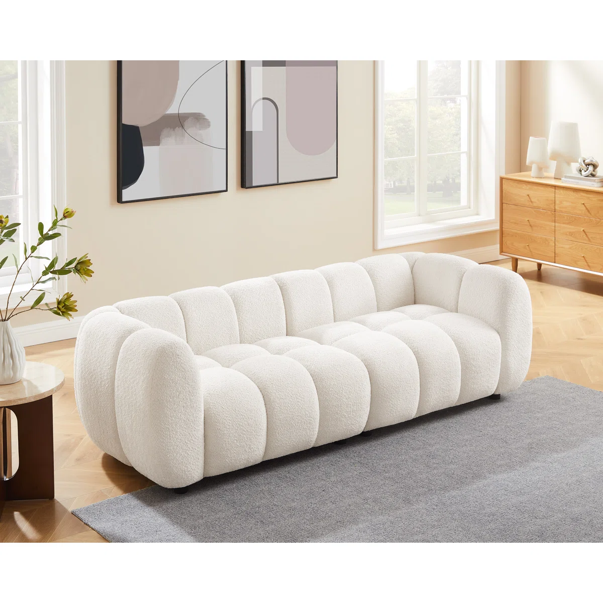 White tufted boucle sofa with rolled arms and throw pillows in a modern living room setting.