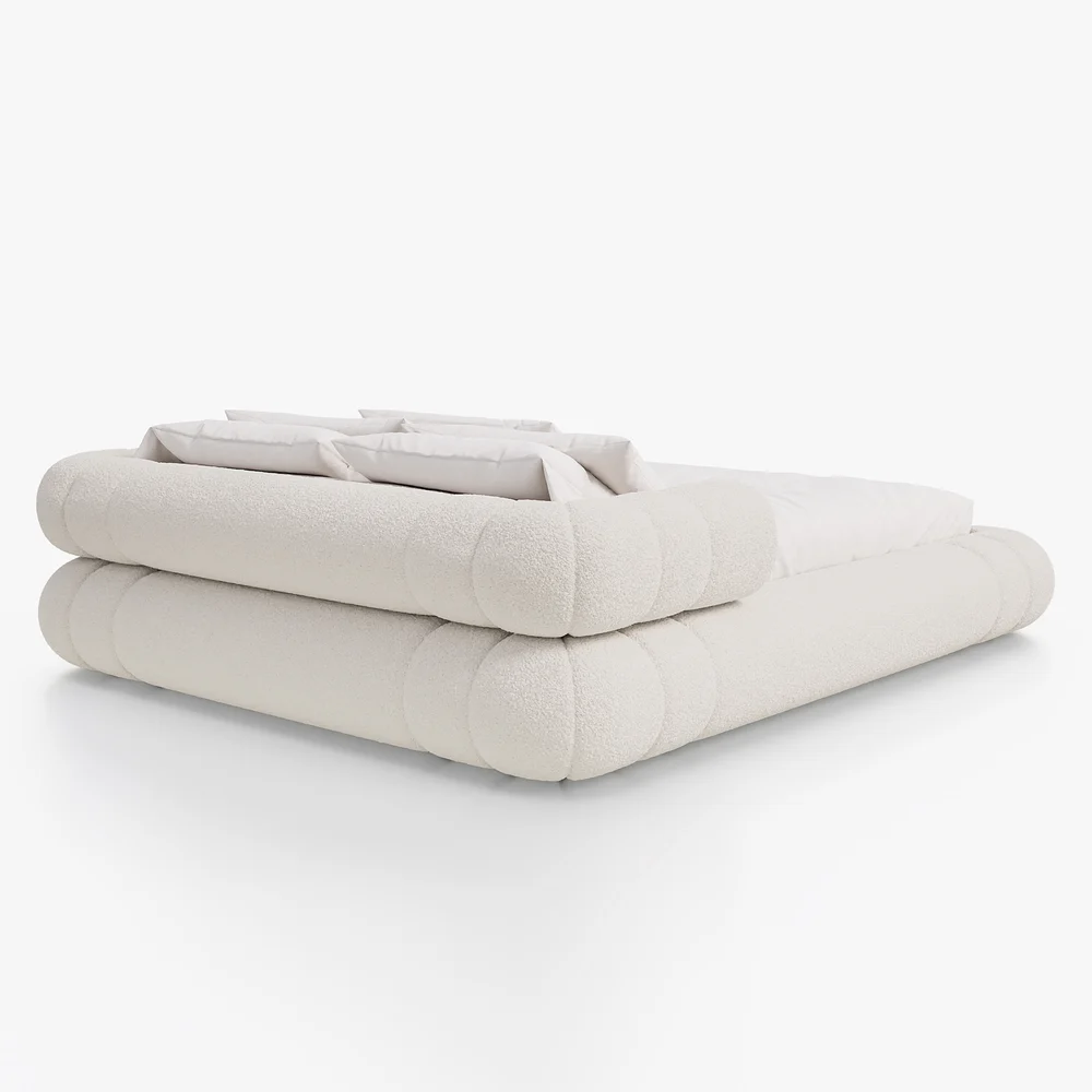 A plush queen-size floor bed upholstered in textured white boucle fabric, featuring a rounded frame and a sculptural headboard