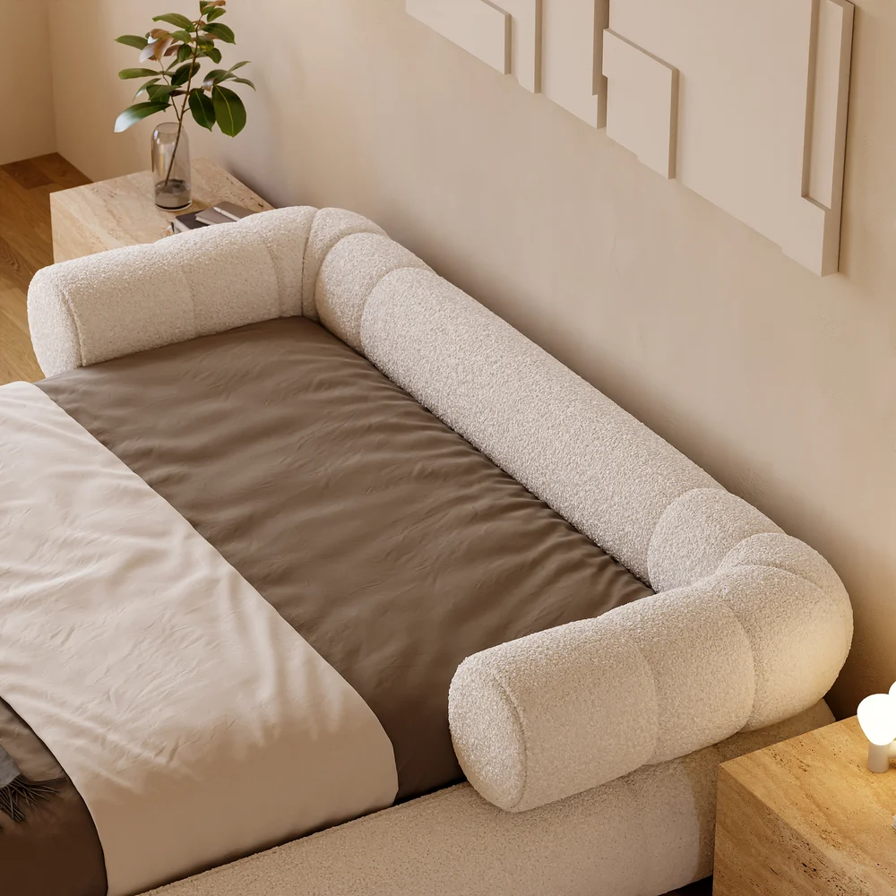 A plush queen-size floor bed upholstered in textured white boucle fabric, featuring a rounded frame and a sculptural headboard