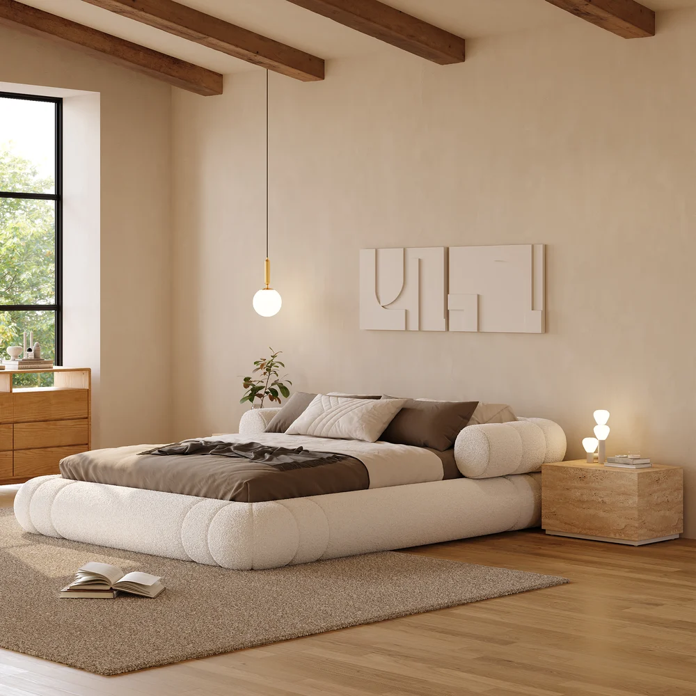 A plush queen-size floor bed upholstered in textured white boucle fabric, featuring a rounded frame and a sculptural headboard