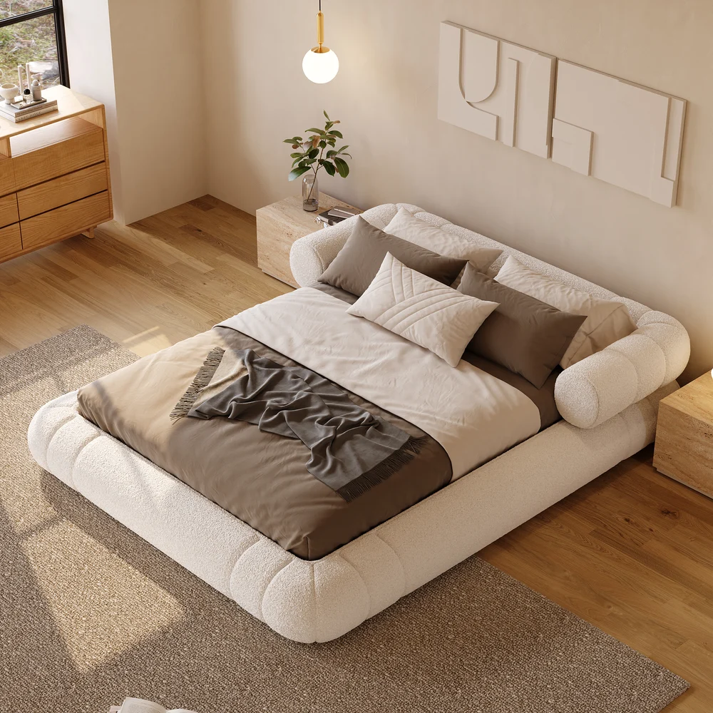 A plush queen-size floor bed upholstered in textured white boucle fabric, featuring a rounded frame and a sculptural headboard