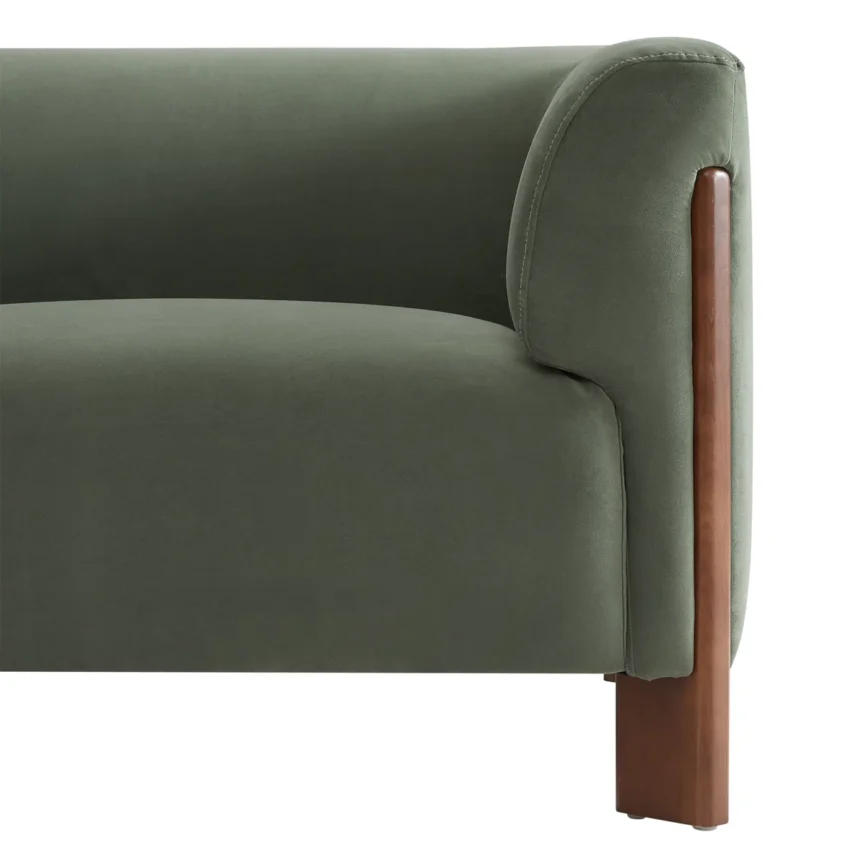 Green sofa with wooden legs and cream throw in a bright, minimalist living room with large
