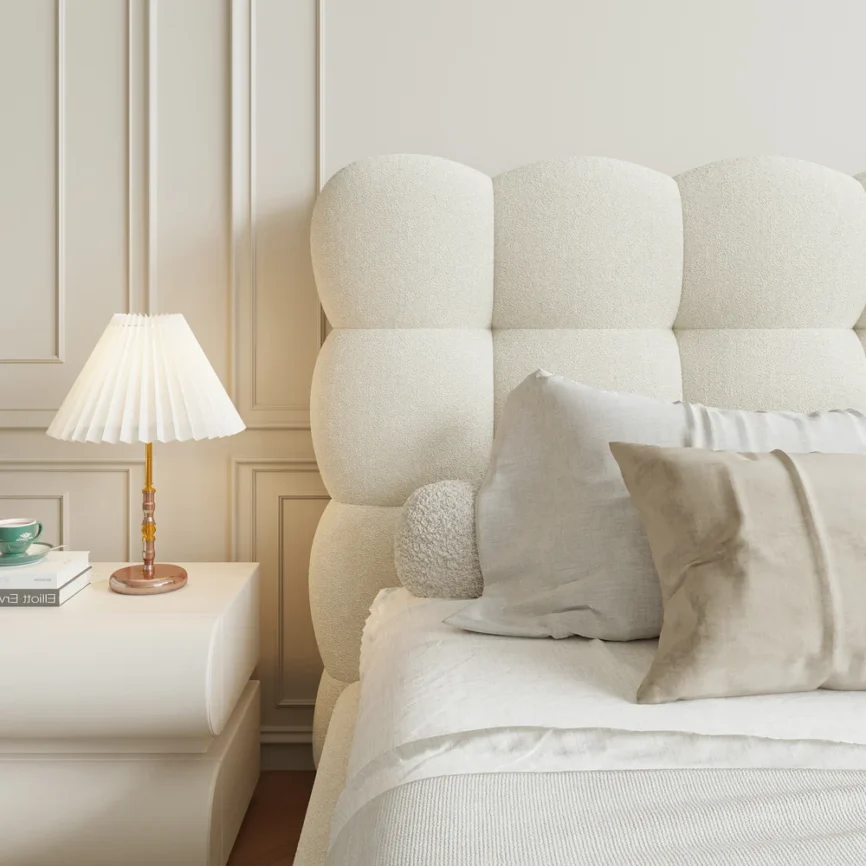 A luxurious bedroom featuring a cream upholstered platform bed with a tufted headboard