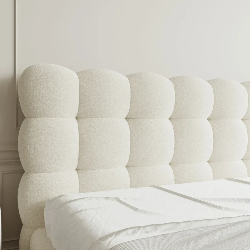 A luxurious bedroom featuring a cream upholstered platform bed with a tufted headboard