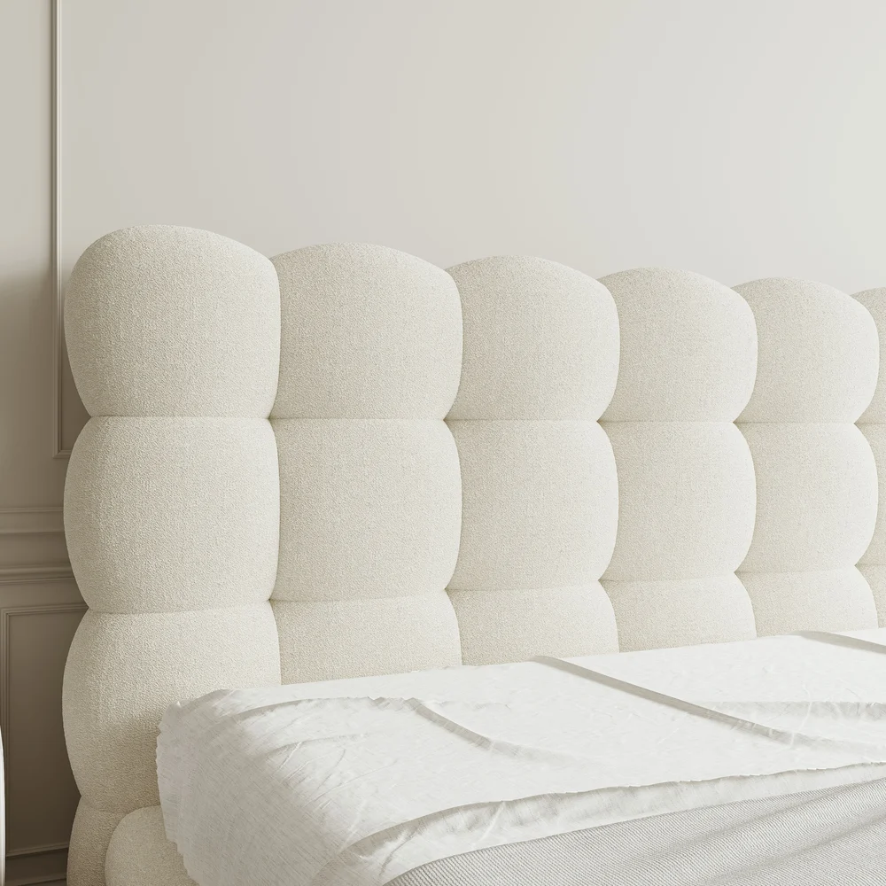 A luxurious bedroom featuring a cream upholstered platform bed with a tufted headboard