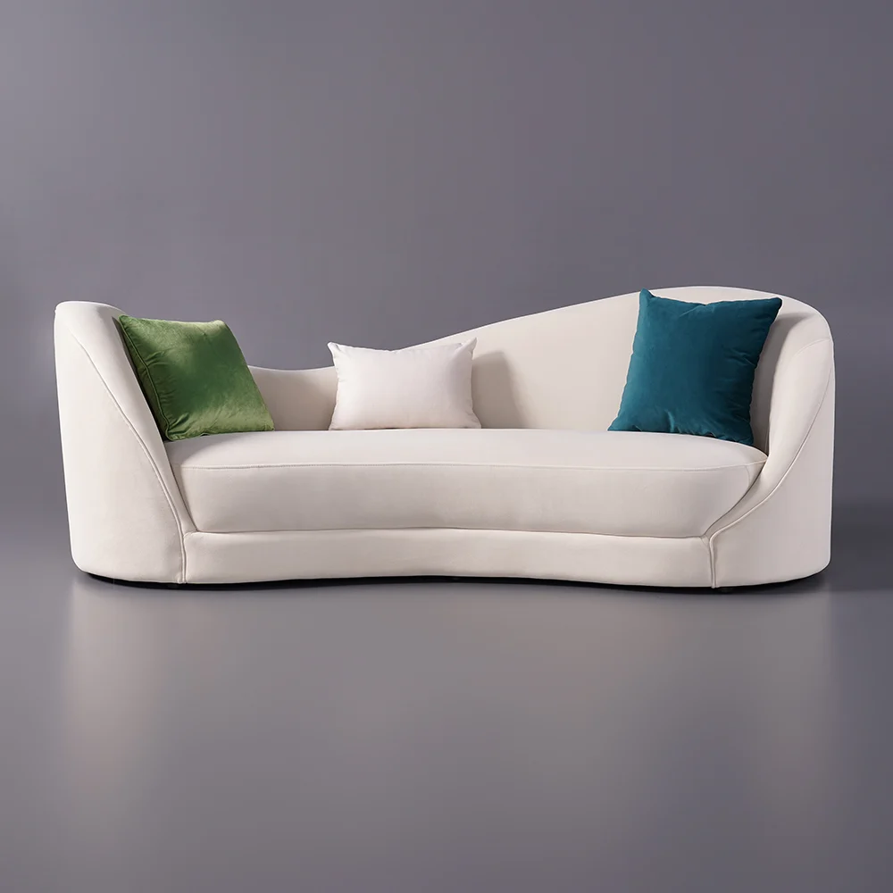 White curved 3-seater sofa with throw pillows and gold coffee table in a modern minimalist living room