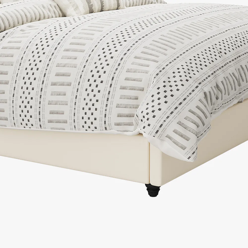 A modern bedroom featuring the Luna Beige Leather Bed, styled with a neutral-toned comforter and five decorative pi