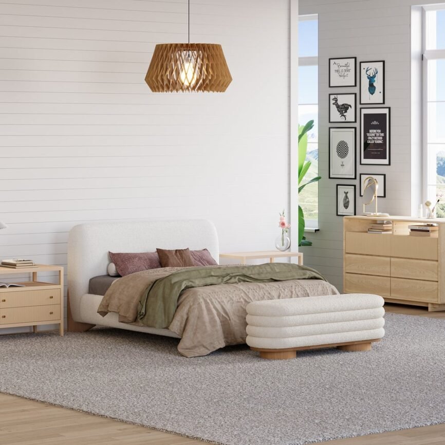 White boucle upholstered bed with padded headboard, gray bedding, and white nightstands in a minimalist bedroom.