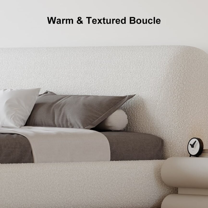 White boucle upholstered bed with padded headboard, gray bedding, and white nightstands in a minimalist bedroom.