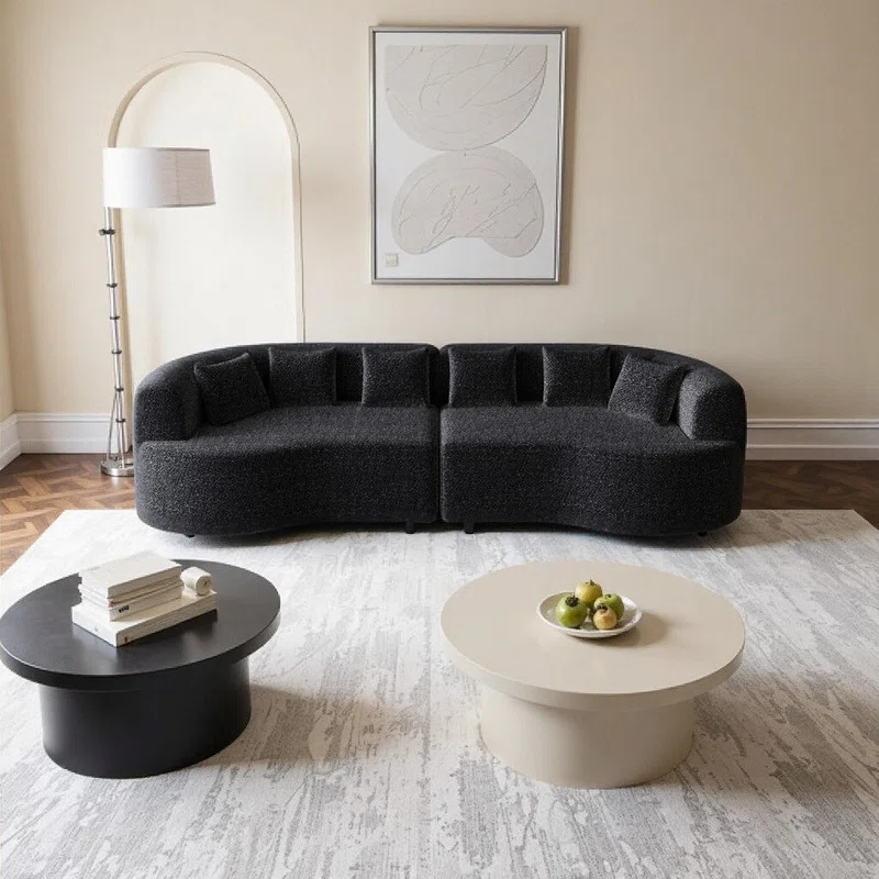 Modern dark green corduroy sofa with ribbed fabric, rounded arms, and wooden legs in a sunlit room.