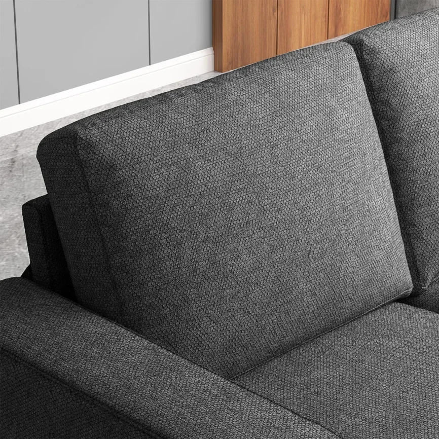 Gray three-seat sofa with textured fabric, accent pillows, and throw blanket in a stylish living room.