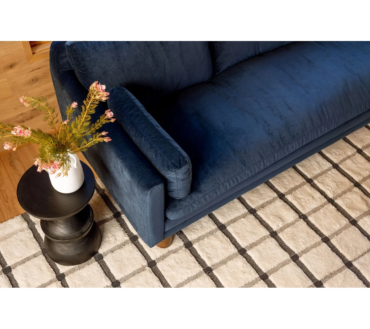Modern dark blue sofa with three cushions, square arms, and wooden legs, highlighting modular section