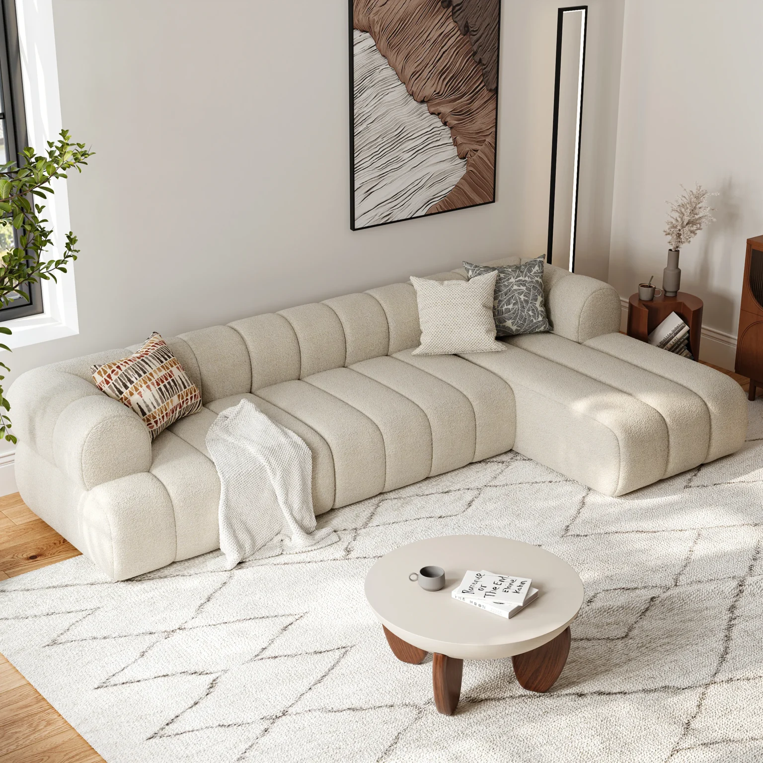 Light beige channel-tufted sectional sofa with throw pillows and blanket in a cozy modern living room