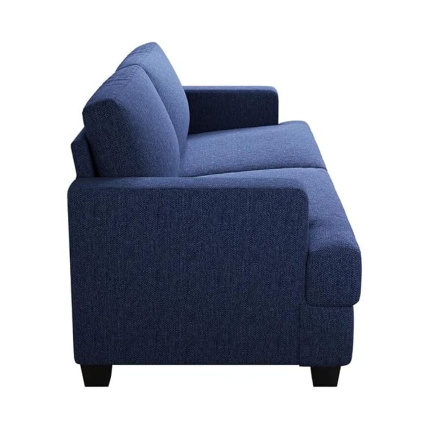 Blue upholstered sofa with houndstooth and beige pillows, throw blanket, and natural light in modern living room