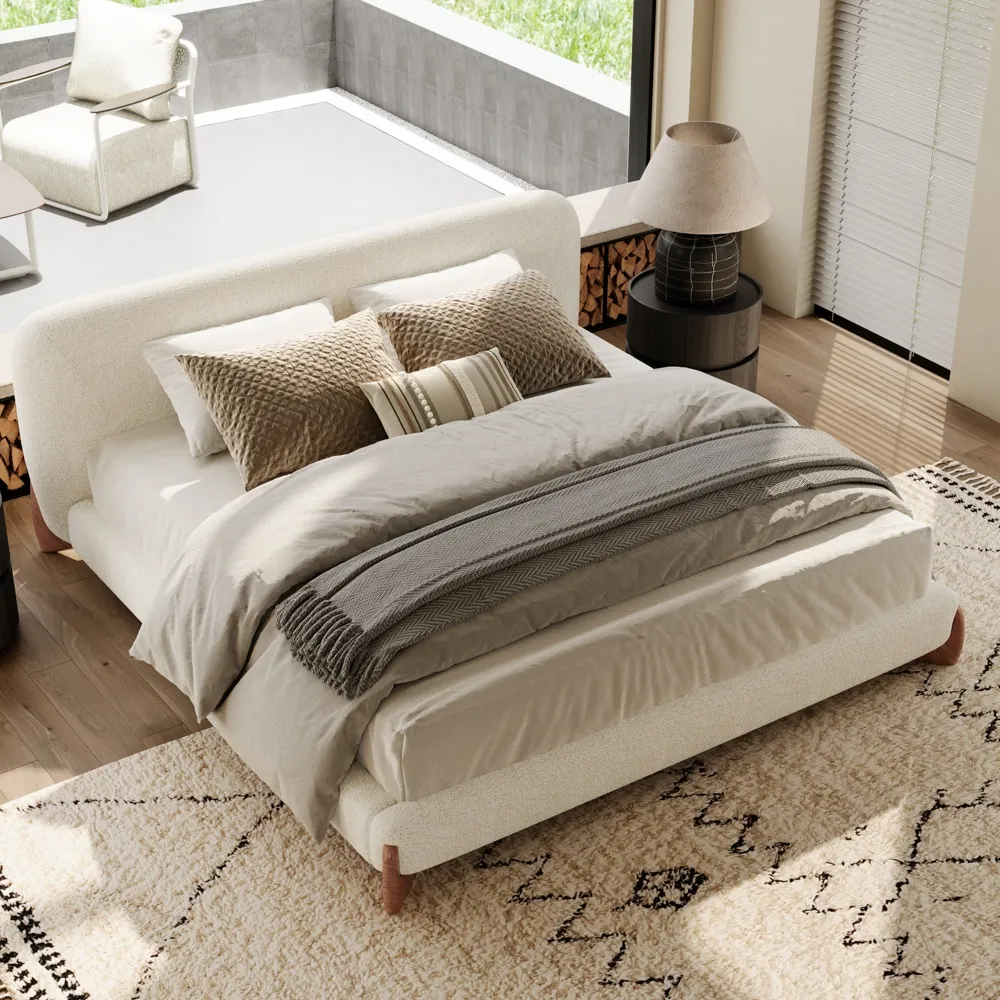A minimalist upholstered bed in textured white boucle fabric with rounded edges and outward-curving wooden legs.
