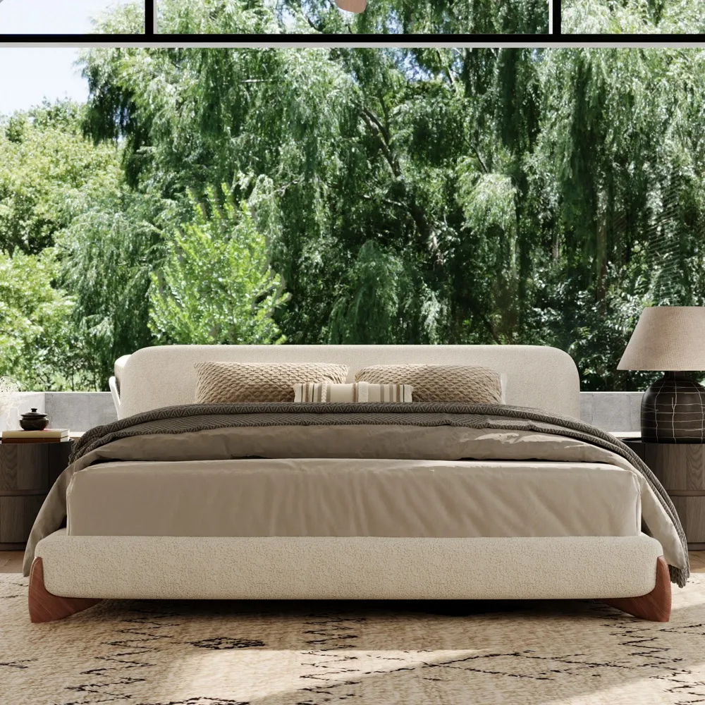 A minimalist upholstered bed in textured white boucle fabric with rounded edges and outward-curving wooden legs.