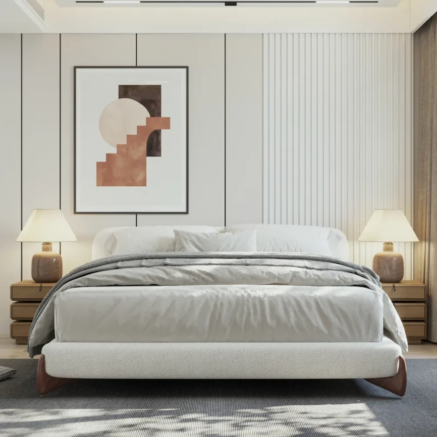 White boucle upholstered bed with curved wooden legs, gray bedding, and a dark throw in a modern room.
