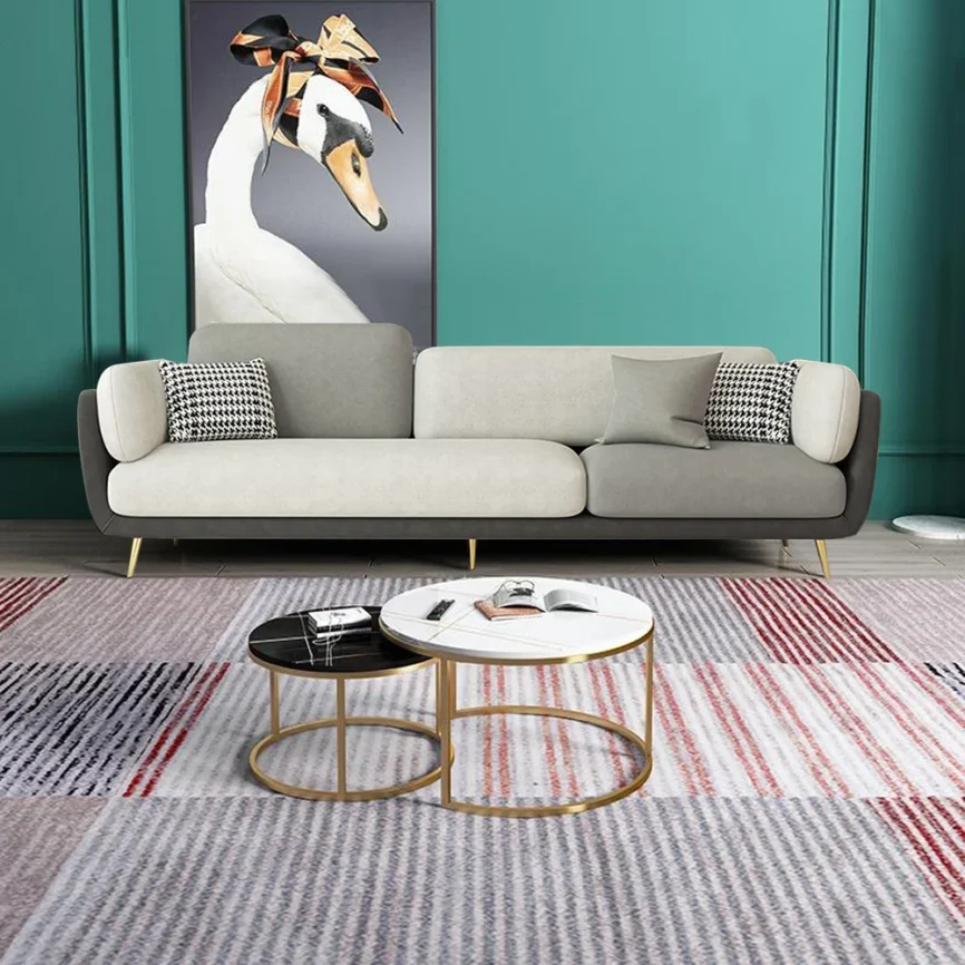 Two-tone gray 4-seater sofa with gold legs and patterned cushions in a contemporary living room