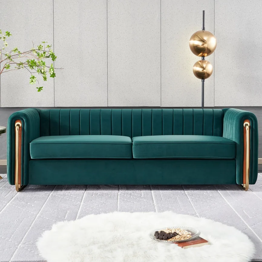 Green velvet sofa with vertical tufting and gold armrest accents in a stylish contemporary room.