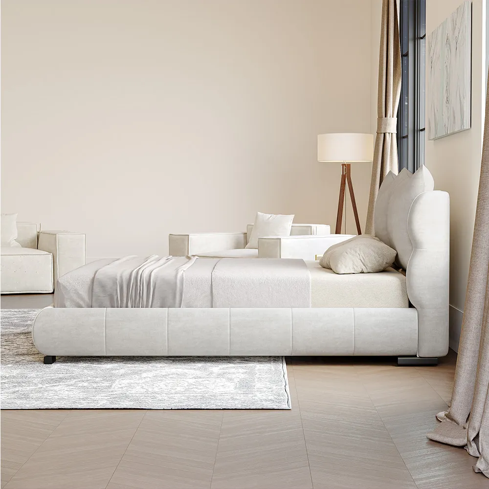 A modern upholstered queen bed in soft beige fabric with a rounded, cushioned frame and short black legs