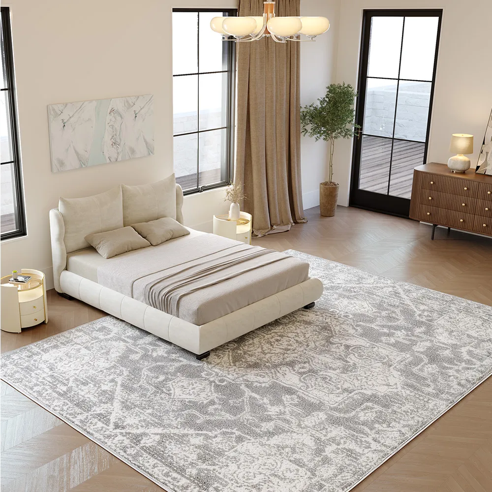 A modern upholstered queen bed in soft beige fabric with a rounded, cushioned frame and short black legs