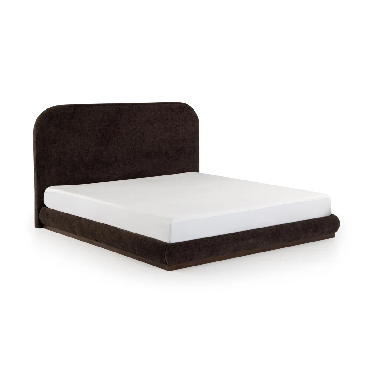 A king-size bed with a dark upholstered headboard, styled in crisp white bedding and layered pillows in neutral tones.