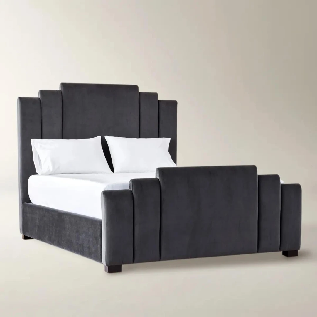 Gunmetal velvet bed with geometric tufted headboard and footboard, styled with white bedding in a modern room.