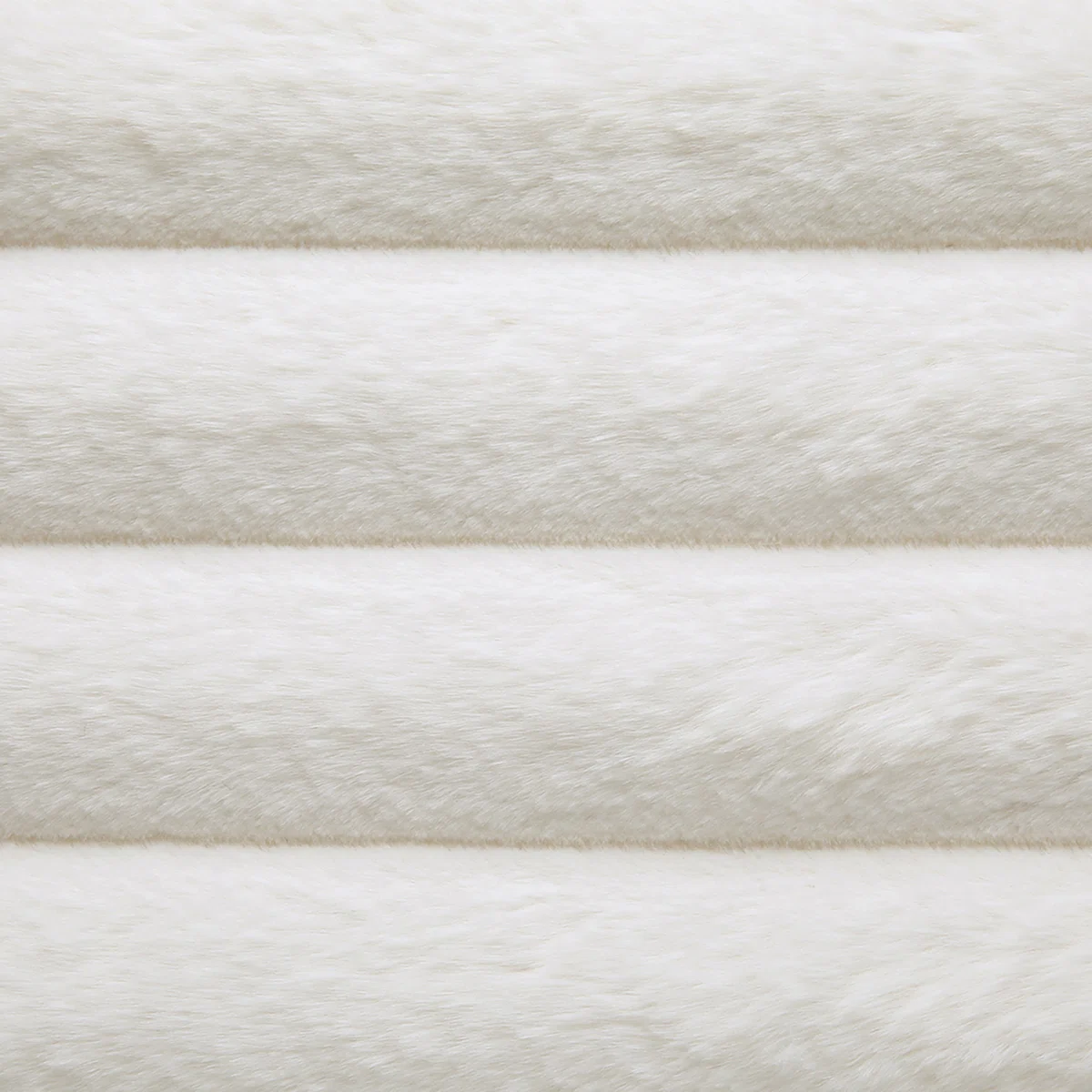 Luxurious bedroom with tall cream upholstered bed, white linens, floral side table, and elegant decor.