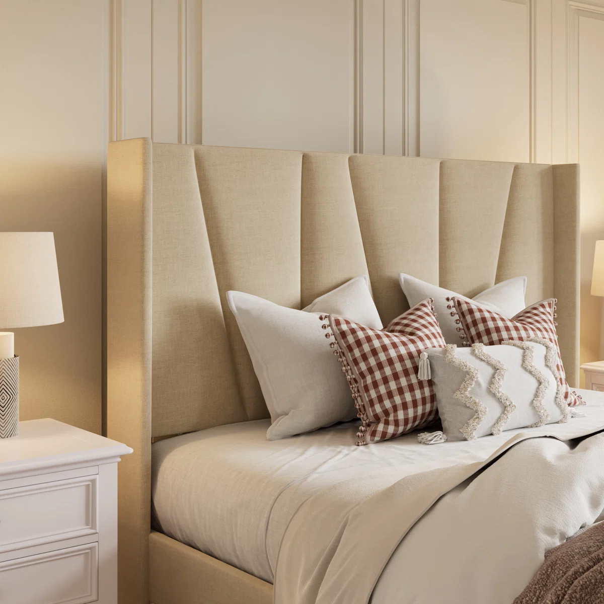 Beige upholstered bed with layered pillows, brown throw, white nightstands, and matching lamps in a cozy bedroom.