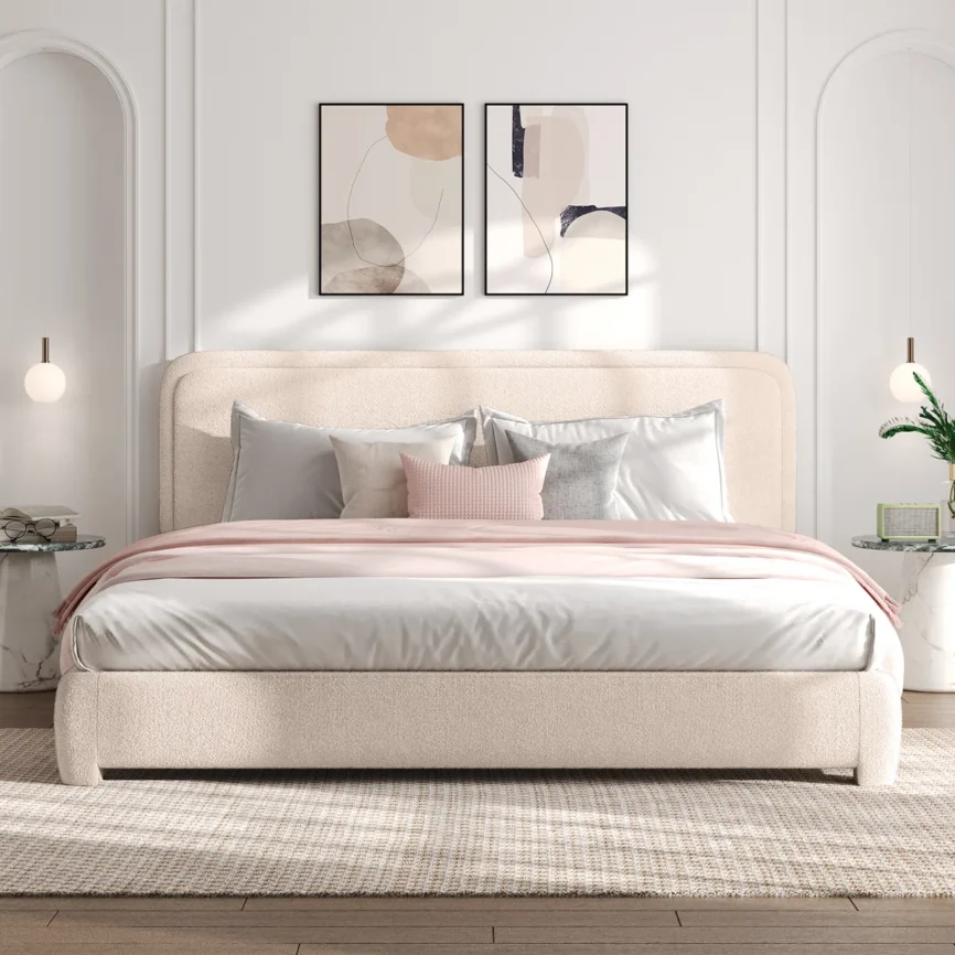 Beige upholstered bed with white and gray bedding, light wood nightstands, and abstract wall art in a modern bedroom.
