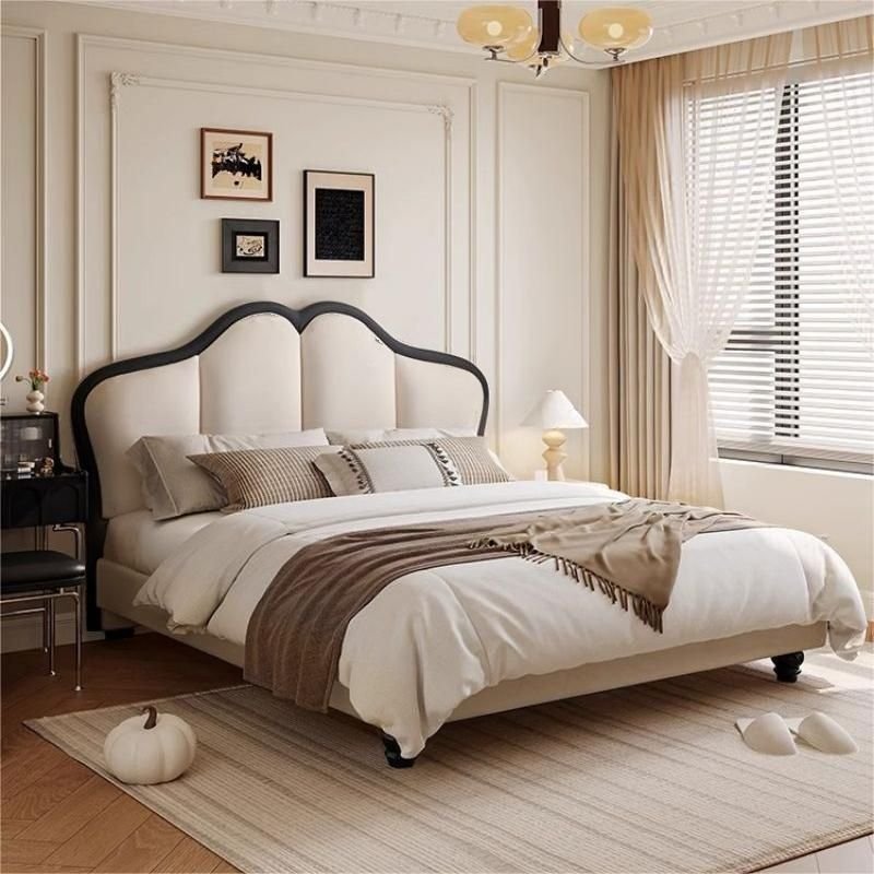 A modern bedroom featuring a white upholstered bed with a curved panel headboard outlined in black