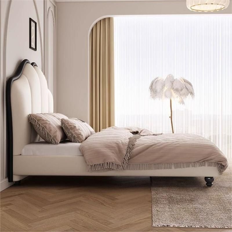 A modern bedroom featuring a white upholstered bed with a curved panel headboard outlined in black