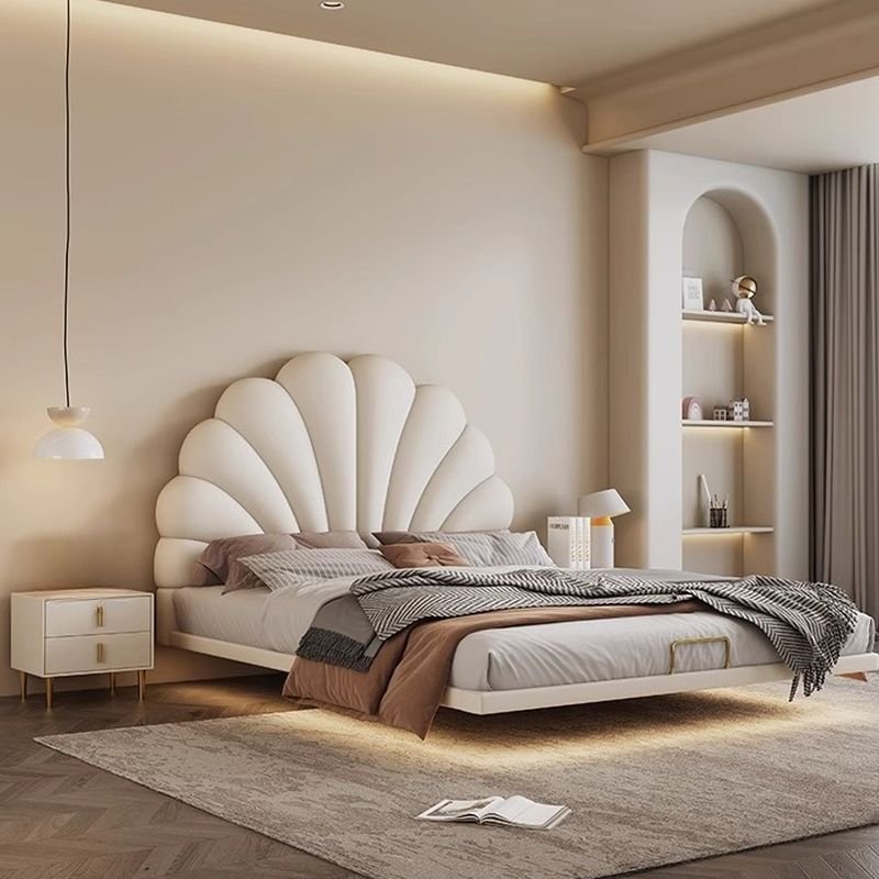 White shell-shaped upholstered bed with neutral bedding, gold-accented nightstands, and warm modern decor.
