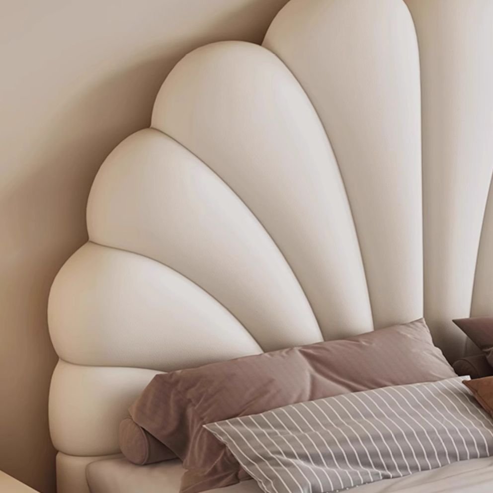 White shell-shaped upholstered bed with neutral bedding, gold-accented nightstands, and warm modern decor.