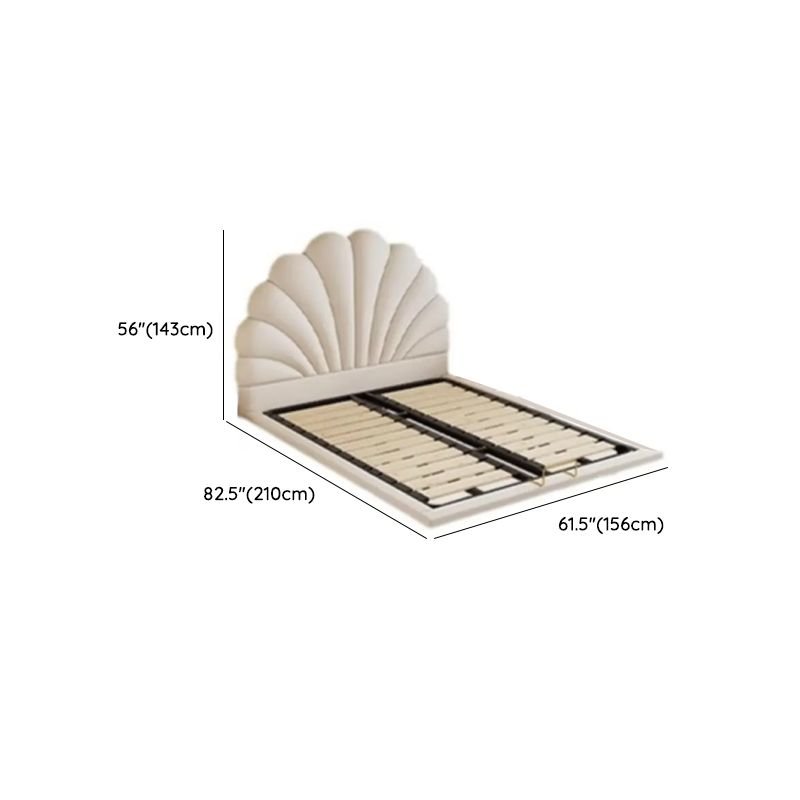 White shell-shaped upholstered bed with neutral bedding, gold-accented nightstands, and warm modern decor.