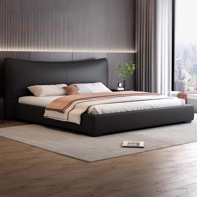 Black curved headboard bed with neutral bedding, modern nightstands, and dark wood-paneled wall.