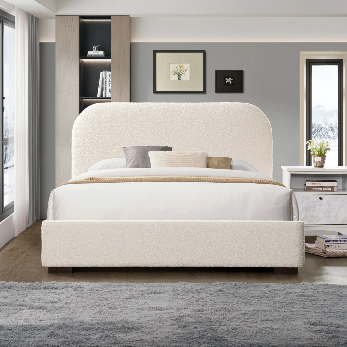 Cream boucle bed with rounded headboard, white bedding, neutral pillows, and built-in shelf in a cozy bedroom.