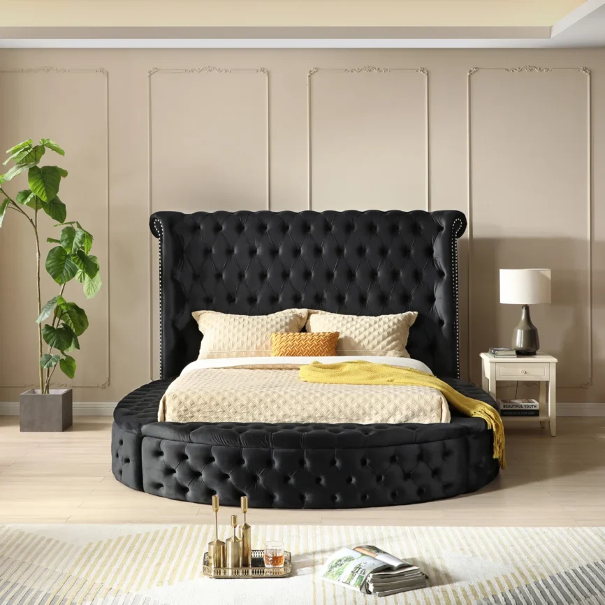 Black velvet round bed with tufted wingback headboard and open storage compartments in a modern city-view bedroom.