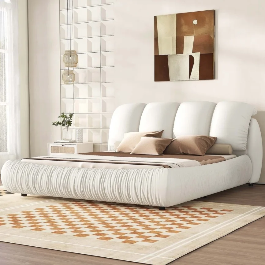 White upholstered bed with panel headboard and gathered footboard, beige bedding, and checkered flooring in a modern bedroom
