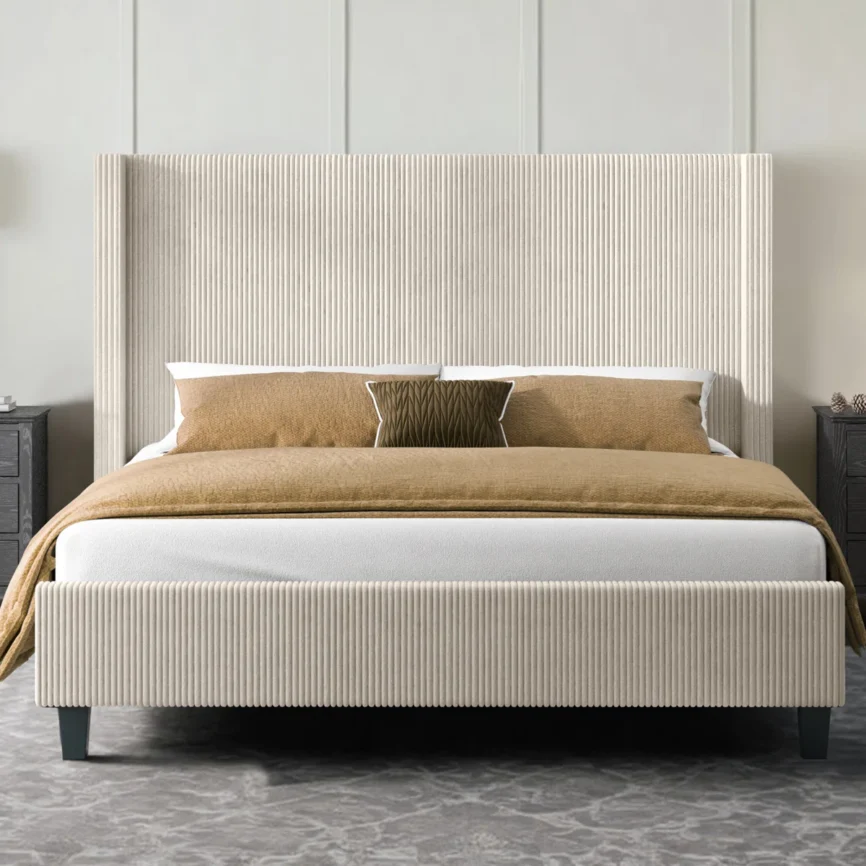 Beige upholstered bed with ribbed headboard, layered pillows, tan comforter, and dark nightstand in a modern bedroom.