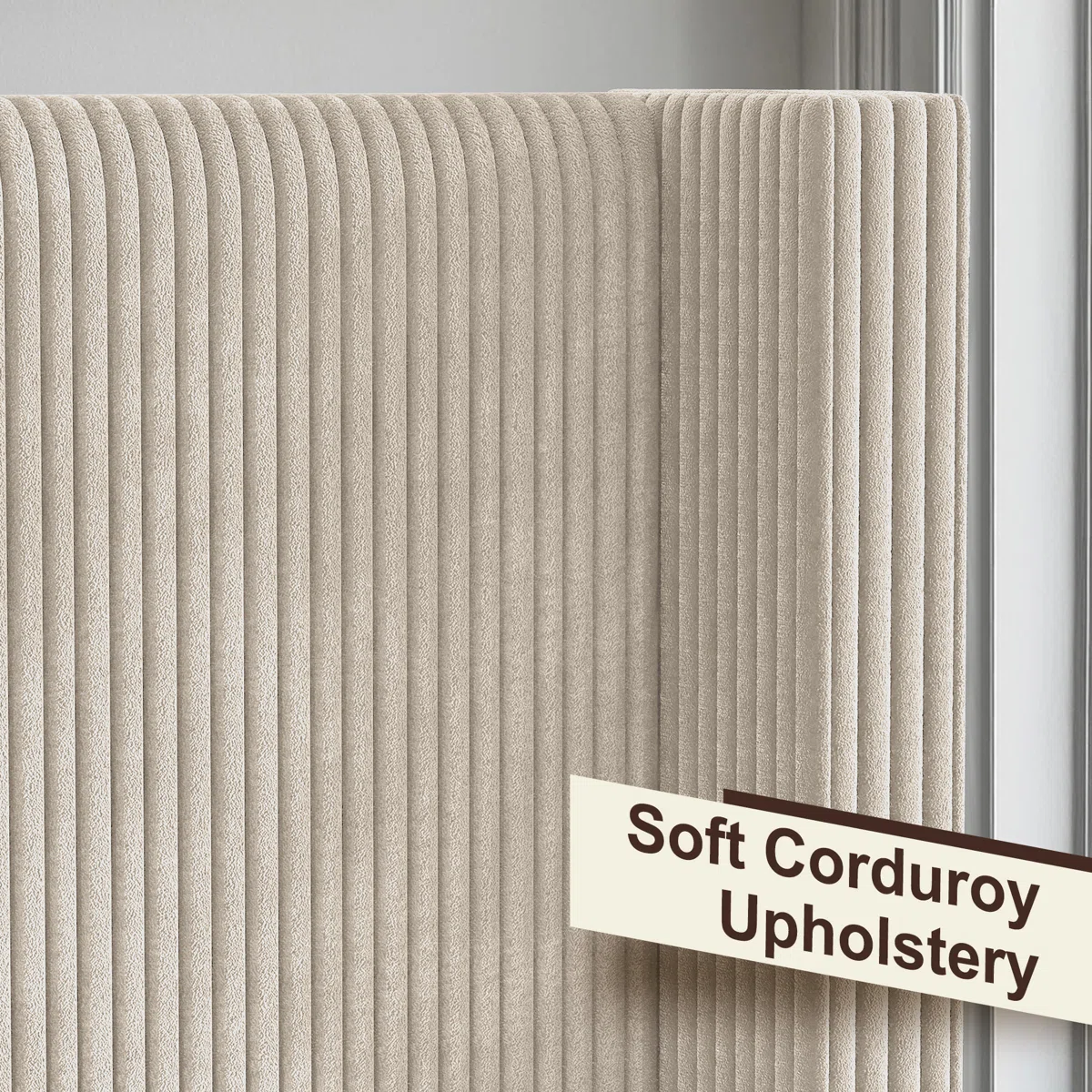 Beige upholstered bed with ribbed headboard, layered pillows, tan comforter, and dark nightstand in a modern bedroom.