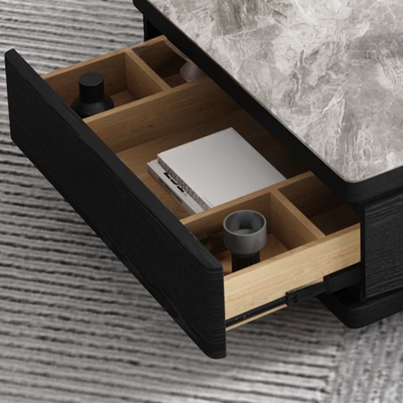 Modern funky coffee table with midnight black sintered stone rectangular top, black block base, and three storage drawers