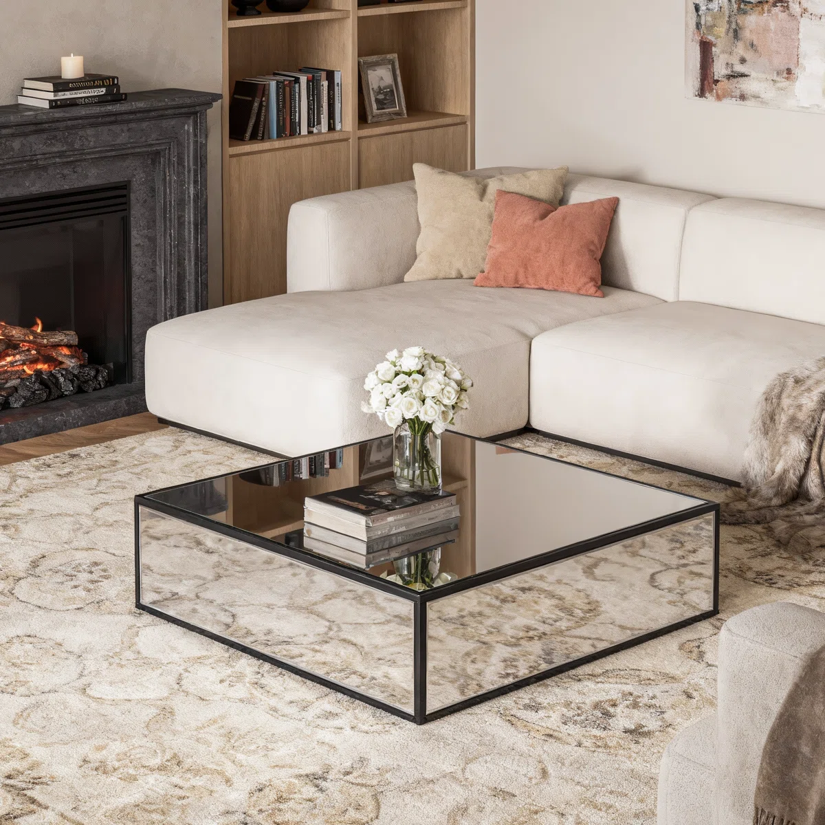 Square silver mirrored coffee table with reflective glass top and black metal frame, modern living room furniture piece"
