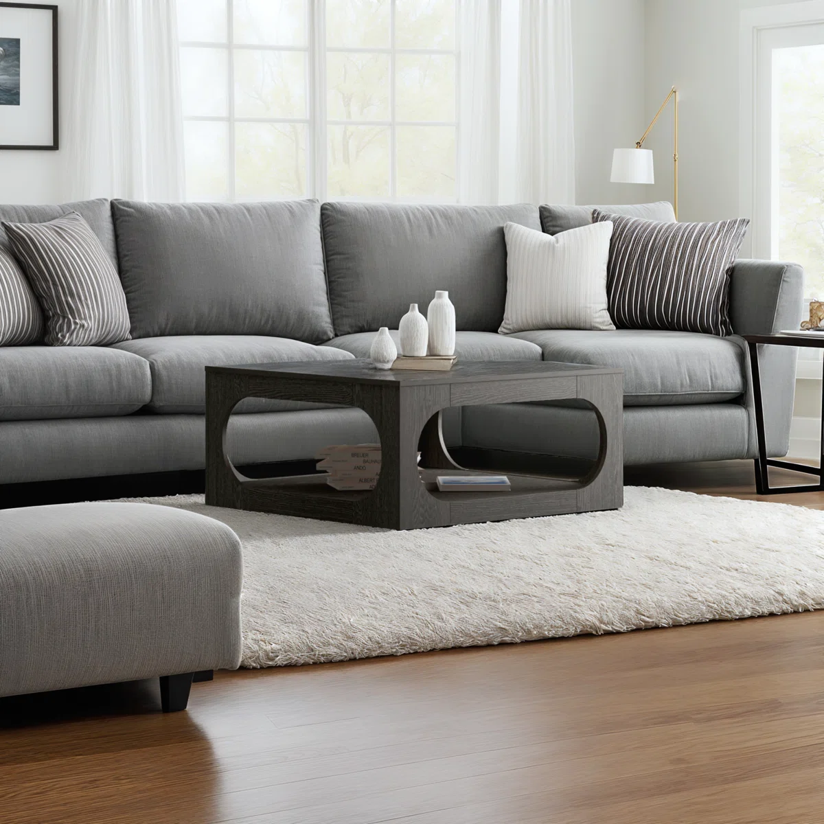 Square coffee table with oval cutout sides, spacious tabletop, and lower storage shelf, finished in modern gray with block feet.