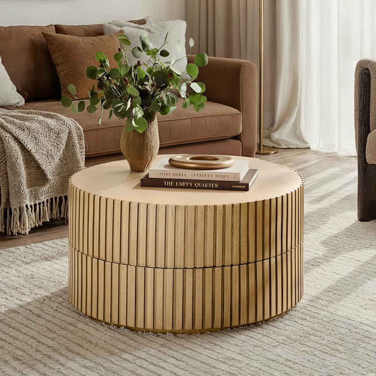 Round swivel‑top coffee table with dual rotating surfaces, fluted base, and natural birch veneer finish, styled as a modern centerpiece in a living room.