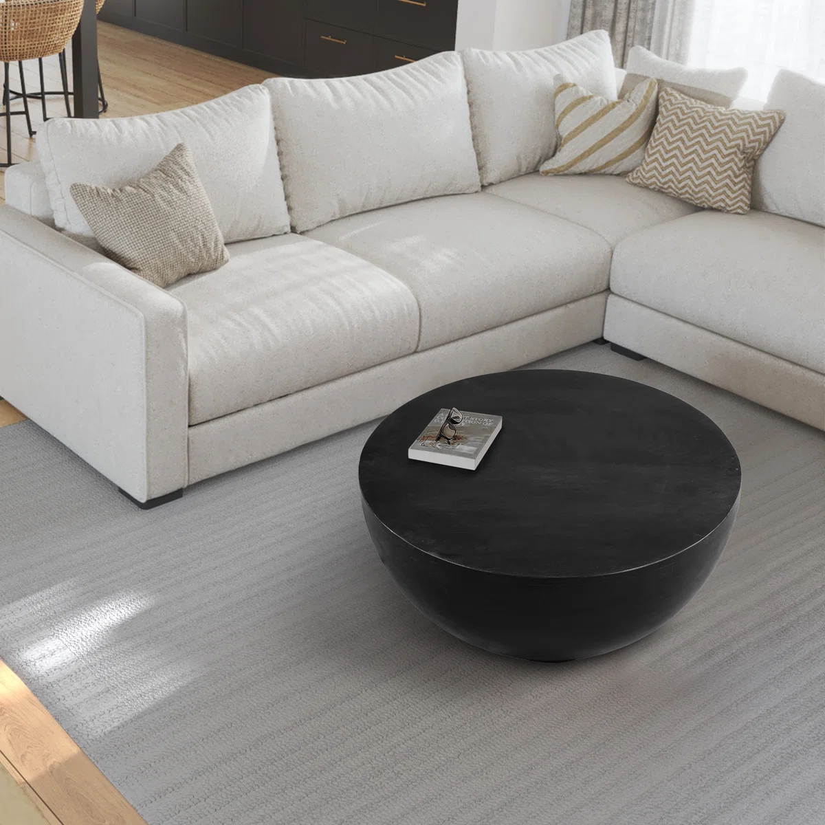 Ebonora round solid wood coffee table with matte black finish, drum silhouette, and tapered base, 76 cm wide.